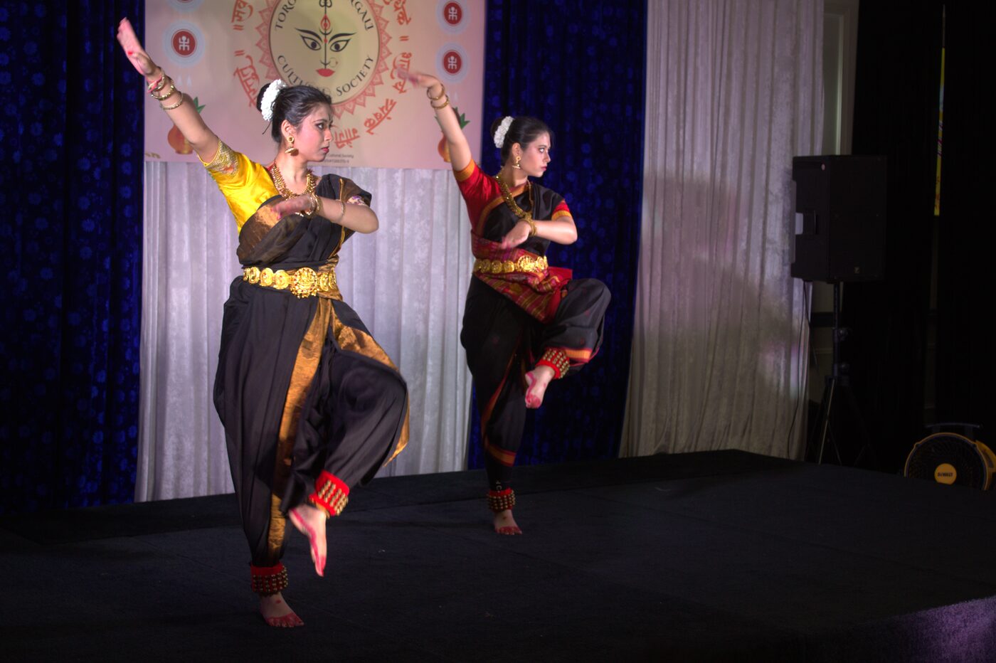 Two dancers performing a classical dance duet at TBCS Durga Puja