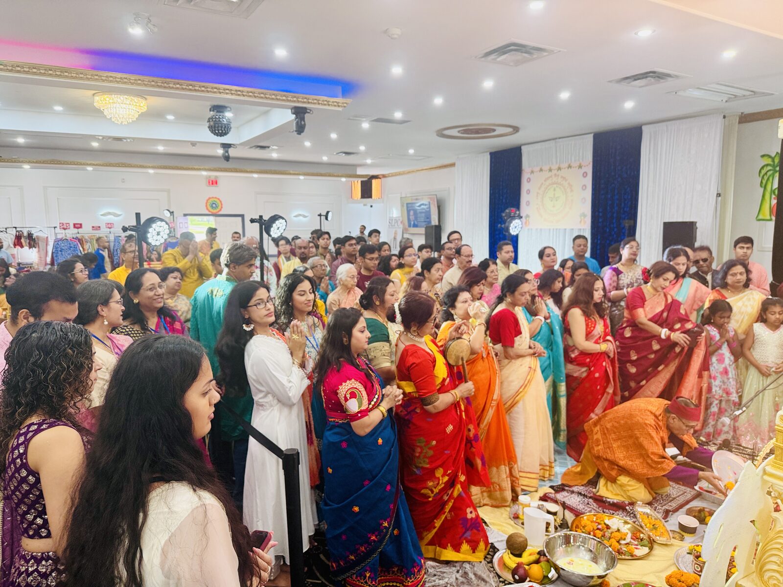Purohit performing evening aarti in front of the community at TBCS Durga Puja