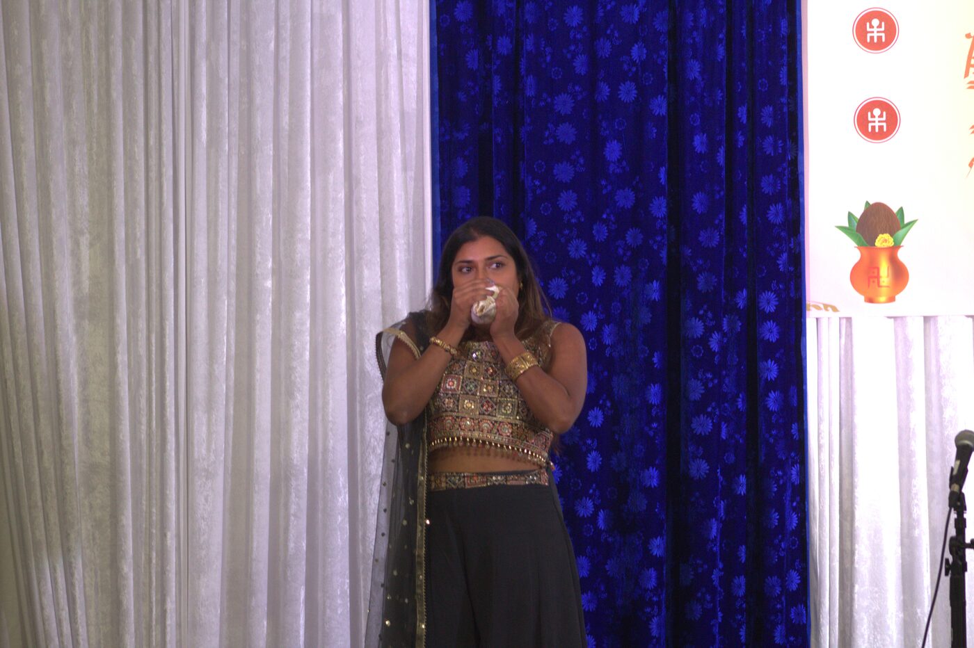 Performer blowing a conch shell (shankha) on stage at TBCS Durga Puja