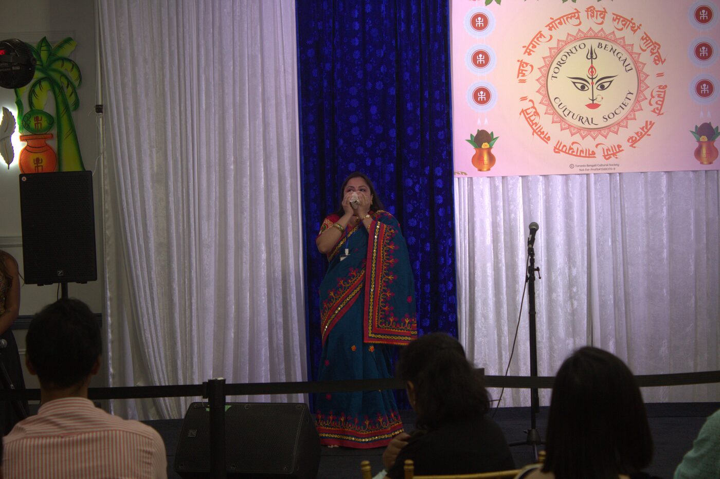 Woman singing on stage at TBCS Durga Puja